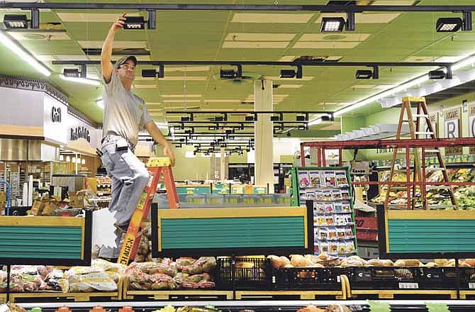 Rehagen Electrical Contracting electrician Jason Wieberg adjusts new LED track lighting at Schulte's Fresh Foods in Jefferson City.