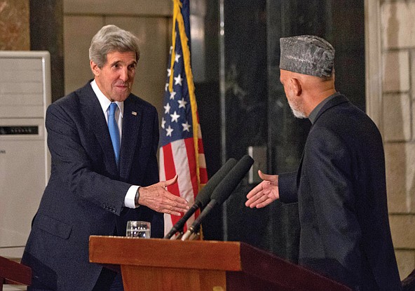 Secretary of State John Kerry reaches to shake hands with Afghan President Hamid Karzai during their joint news conference Monday.
