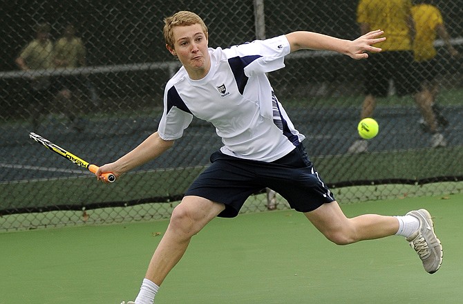 Helias opened the tennis season with a 6-3 loss to Fulton on Wednesday at Washington Park. (Above) Caleb Siedel makes a return during his doubles match. 