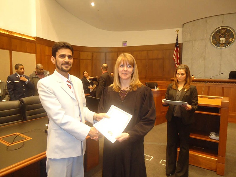 Sardar Sherzad accepts the certificate declaring him a United States citizen March 14 at a ceremony in Kansas City. Sherzad has lived in Fulton since he and his family left his homeland of Afghanistan in 2008.