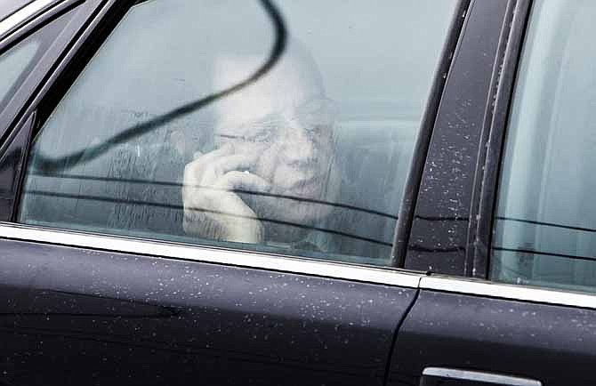 Cypriot President Nicos Anastasiades speaks on his phone in his car March 24 as he arrives at the airport in Brussels. A rescue deal to save Cyprus' banks will affect other European countries.