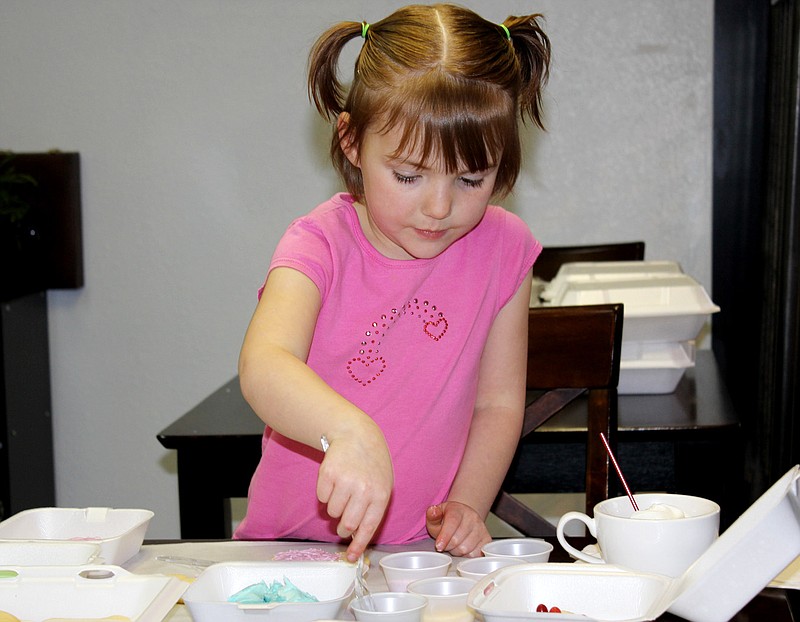 Clara Underwood, daughter of Malissa Underwood of New Bloomfield, decorates Easter cookies Saturday at Cafe Creme, 510 S. Business 54 in Fulton. Cafe Creme provides the cookies and the decorating materials for children to use at special cooking classes during holidays throughout the year.