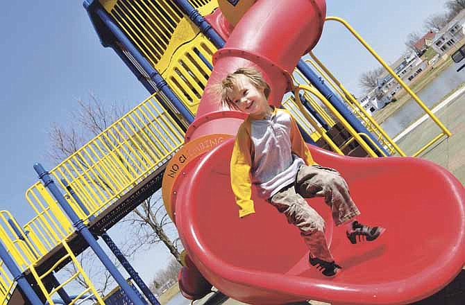 Friday's warm weather brought out the young and young-at-heart in Jefferson City to McKay Park's children's playground. Six-year-old Eli Neff enjoys the slide at the Parks and Recreation playground. 