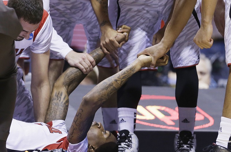 Louisville players talk to guard Kevin Ware after his injury during the first half of Sunday's game against Duke in Indianapolis.