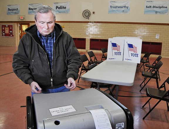 Ken Adams feeds his ballot into the automatic reader as he casts his vote at Moreau Heights School during Tuesday's general election. Moreau Heights is the polling place for residents of Ward 5, Precinct 3.