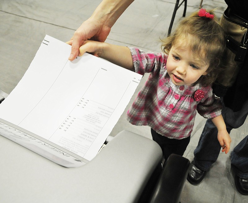 Learning her civic duty at an early age, two-year-old Rylee Lueckenotte gets a little help from her mom, Kim, to feed the ballot into the reader Tuesday at the Blair Oaks polling location. Because of the boundaries, voters at the Blair Oaks polling location had five ballots from which to select to cast their vote on issues and candidates. Some residents are still in the Jefferson City School District while most are in the Blair Oaks District. 