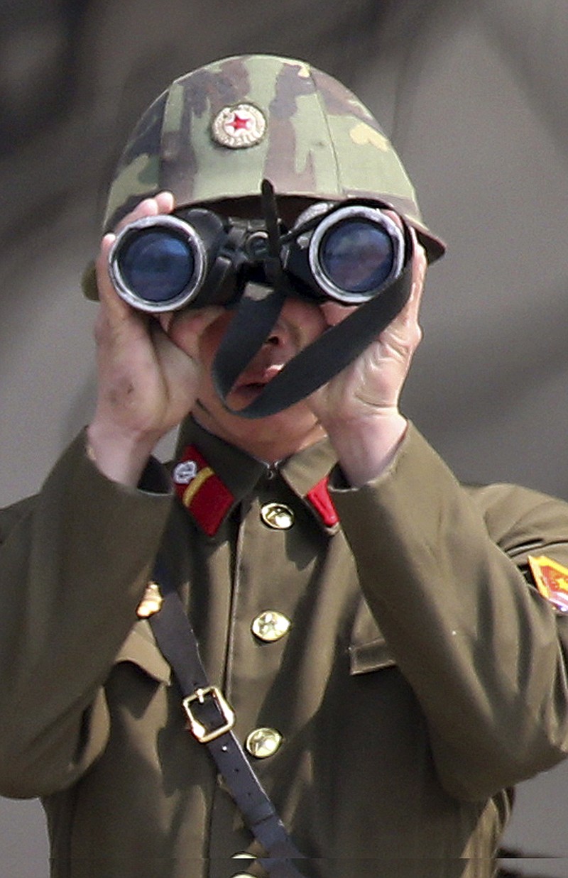 A North Korean soldier uses a pair of binoculars to watch the South Korean side at the border village of Panmunjom in the demilitarized zone (DMZ) in South Korea. South Korea's defense minister said Thursday North Korea has moved a missile with "considerable range" to its east coast, but said it is not capable of hitting the United States. 