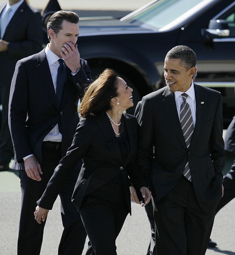President Barack Obama walks with California Attorney General Kamala Harris, center, and California Lt. Gov. Gavin Newsom after arriving at San Francisco International Airport in San Francisco. Obama praised California's attorney general for more than her smarts and toughness at a Democratic Party event Thursday. The president also commended Harris for being "the best-looking attorney general" during a Democratic fundraising lunch in the Silicon Valley.