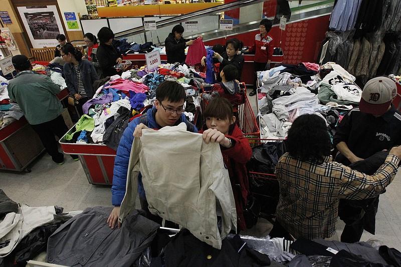 Customers choose clothes to buy at a discount store in Seoul, South Korea, on Friday. Foreigners unused to North Korean rumblings have canceled trips to the Korean Peninsula. But to get South Koreans' attention, Pyongyang must compete with the economy, celebrity scandals, baseball games and cherry blossoms.