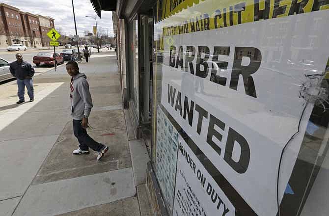 This Friday, March 29, 2013 file photo shows a help wanted sign at a barber shop in Richmond, Va. U.S. employers added just 88,000 jobs in March, the fewest in nine months and a sharp retreat after a period of strong hiring. Many discouraged Americans are giving up the job hunt for school, retirement and disability.