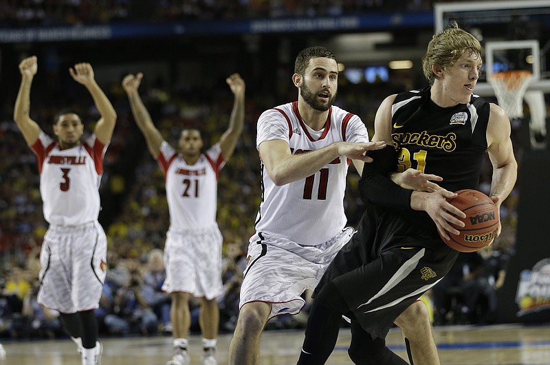 Wichita State's Ron Baker (31) and Louisville's Luke Hancock move during the second half of the NCAA Final Four tournament college basketball semifinal game Saturday, April 6, 2013, in Atlanta. Louisville won 72-68.