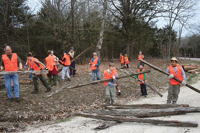 Area Boy Scouts remove old rails before replacing them in a split rail fence at the Lake of the Ozarks State Park over the weekend.