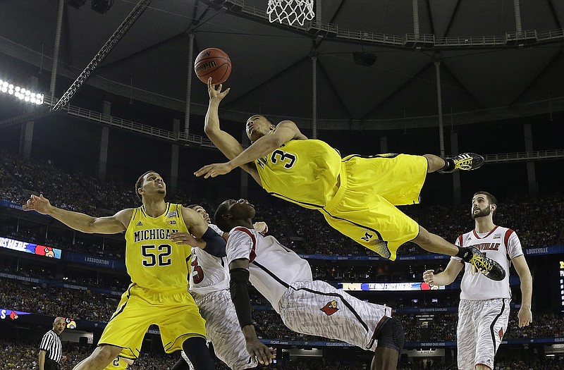 Michigan guard Trey Burke (3) shoots over Louisville center Gorgui Dieng (10) during the second half of Monday night's game in Atlanta.