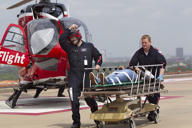 Life Flight personnel rush a victim wounded in a stabbing attack on the Lone Star community college system's Cypress, Texas campus into Memorial Hermann Hospital on Tuesday, in Houston. More than a dozen people were wounded when a suspect went building-to-building in an apparent stabbing attack at the college campus authorities said.