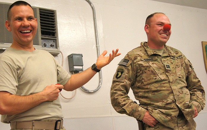 U.S. Army Capt. John Morris, right, plays along with a joke by Maj. Bruce Townley, a native of Chamois, at Forward Operating Base Lightning in Afghanistan on March 31. Townley performed an Easter show for the soldiers. 