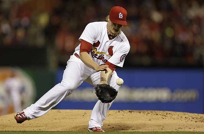 St. Louis Cardinals starting pitcher Shelby Miller handles a ground ball hit by Milwaukee Brewers' Jonathan Lucroy during the fourth inning of a baseball game on Friday, April 12, 2013, in St. Louis. Miller was able to throw Lucroy out at first. 