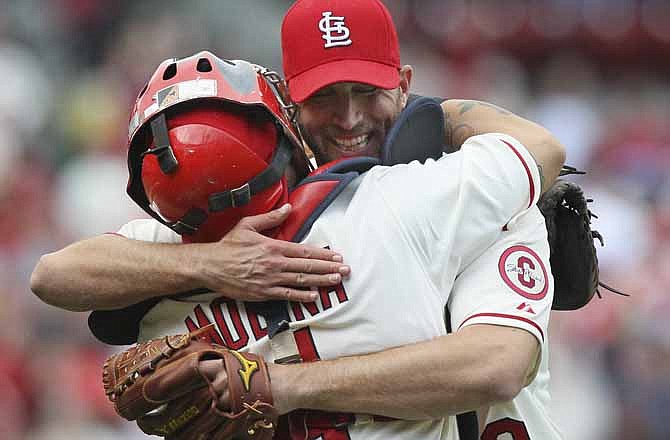 St. Louis Cardinals starting pitcher Adam Wainwright hugs catcher Yadier Molina, back to camera, after pitching a complete game shutout against the Milwaukee Brewers on Saturday, April 13, 2013, at Busch Stadium in St. Louis. 