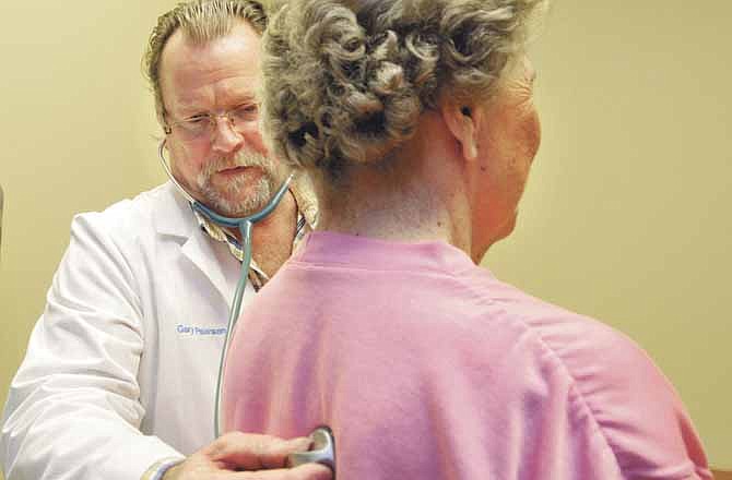 Dr. Garry Pearson of St. Mary's Jefferson City Medical Clinic listens as patient Iola Potts of Tipton, Mo., breathes deeply during an exam. Potts was a patient at the Tipton clinic, but drives to Jefferson City to see her favorite doctor.