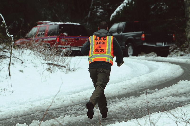 A man with King County Search and Rescue runs toward the scene of an avalanche at exit 47 along I-90 near Snoqualmie Pass.