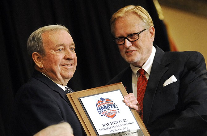 Former Helias football coach Ray Hentges (left) accepts his plaque from Jerald Andrews on Sunday after being inducted into the Missouri Sports Hall of Fame during a ceremony at the Capitol Plaza Hotel.