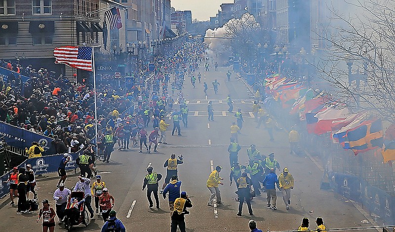 People react as an explosion goes off near the finish line of the 2013 Boston Marathon. Two explosions went off near the race finish line.