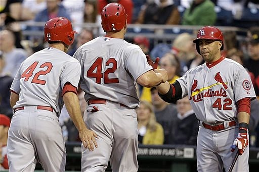 Carlos Beltran (right) greets Cardinal teammates Matt Carpenter (left) and Matt Holliday after they scored on a double by Allen Craig during the second inning of Monday night's game against the Pirates in Pittsburgh.