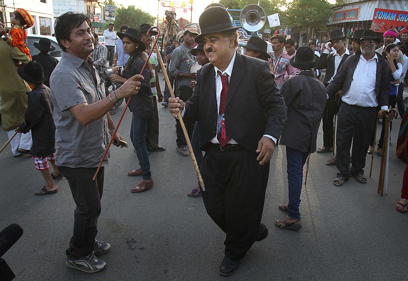 Members and supporters of the Charlie Circle, a Charlie Chaplin fan-club, dance Tuesday during the annual parade to celebrate the birthday of Charlie Chaplin in Adipur, Gujarat state, India. Canes in hand and bowler hats firmly in place, dozens of Charlie Chaplin impersonators tramped through the streets of this small port town in western India to celebrate the birthday of the legendary comic actor and filmmaker.