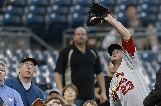 Cardinals third baseman David Freese makes a catch against the fence on a pop by Pedro Alvarez of the Pirates in Wednesday night's game at Pittsburgh.