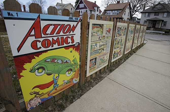 In this Tuesday, April 2, 2013 photo shows oversized Superman comic book pages displayed on a fence outside of what was once Joe Shuster's boyhood home in Cleveland. Superman collaborators Jerry Siegel and Shuster lived several blocks apart in the Glenville neighborhood which shaped their lives, dreams for the future and their imagery of the Man of Steel. 