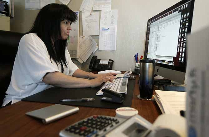 In this Monday, April 15, 2013, photo, Consuelo Gomez, of the facilities management company "Marty K" works in her office, Monday, April 15, 2013, in Bellevue, Wash. 