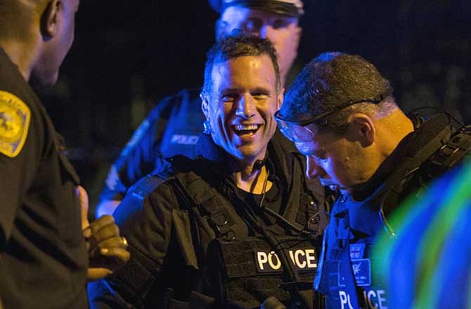 A police officer gives a thumbs up to another in Watertown, Mass. Friday, April 19, 2013, after the manhunt for the second of two suspects in the Boston Marathon bombing was captured. A 19-year-old college student wanted in the Boston Marathon bombings was taken into custody Friday evening after a manhunt that left the city virtually paralyzed and his older brother and accomplice dead. 