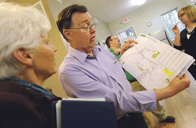 Disability advocate Wayne Lee goes over a JeffTran route map with Vicki Schildmeyer as members of the Citizens for JeffTran group gather at Common Ground Community Center on April 18 to celebrate a vote that week to restore funds to the city's transit division.