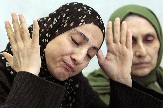 Zubeidat Tsarnaeva, the mother of the two Boston bombing suspects, speaks at a news conference Thursday as her sister-in-law, Maryam, listens in Makhachkala, Dagestan. The suspects' father, Anzor Tsarnaev, said Thursday that he is leaving Russia for the United States in the next day or two, but their mother said she was still thinking it over. 