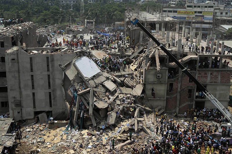 Bangladeshi rescuers look for survivors and victims at the site of a building that collapsed Wednesday in Savar, near Dhaka, Bangladesh. By Thursday, the death toll reached at least 238 people as rescuers continued to search for injured and missing, after a huge section of an eight-story building that housed several garment factories splintered into a pile of concrete. 