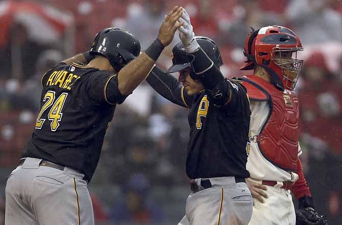 Pittsburgh Pirates' Russell Martin, center, is congratulated by teammate Pedro Alvarez, left, as St. Louis Cardinals catcher Yadier Molina, right, stands by after Martin hit a two-run home run during the seventh inning of a baseball game Saturday, April 27, 2013, in St. Louis. The Pirates won 5-3.