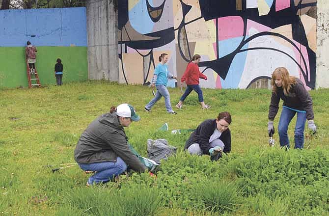 Numerous volunteers participated Saturday to remove graffiti from the community mural and clean up the site near McCarty Street and U.S. 54, as one of the Serve Jeff City projects. 