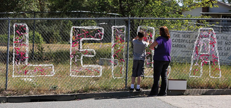 Teacher Cecilia Richardson helps a student Monday tie a ribbon honoring murder victim third-grader Lelia Fowler, at Jenny Lind Elementary School in Valley Springs, Calif. 