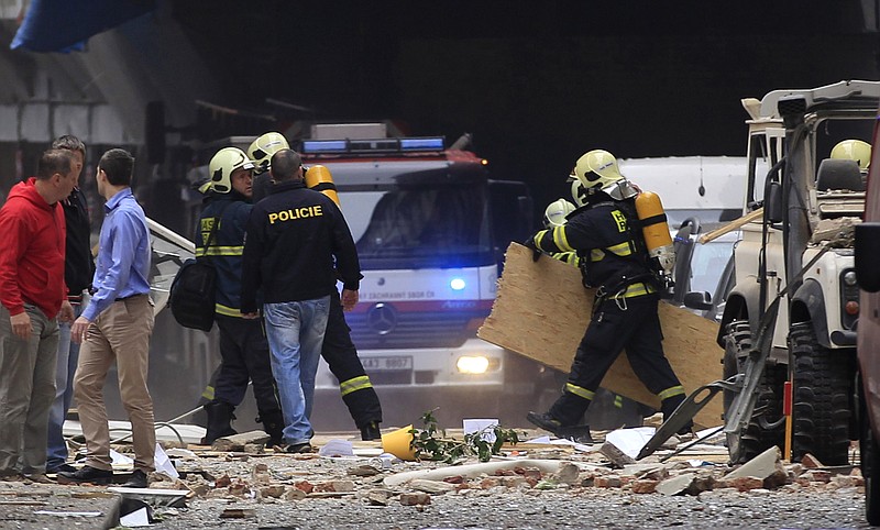 Policemen and firefighters inspect the scene of an explosion in downtown Prague, Czech Republic, Monday. Police said a powerful explosion has damaged a building in the center of the Czech capital, and they believe some people are buried in the rubble.