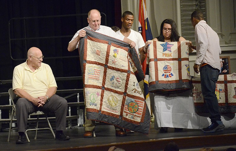 Students of the Jefferson City Academic Center made and presented "Military Quilts" in honor of three distinguished veterans during the Senior Reception held at the Miller Performing Arts Center, where seniors were also presented their certificates and the school was recognized as a recipient of the "State School of Character Award."  The veterans pictured here, Skip Brown, left, and Claude Busby, center, admire the work of the quilts. 