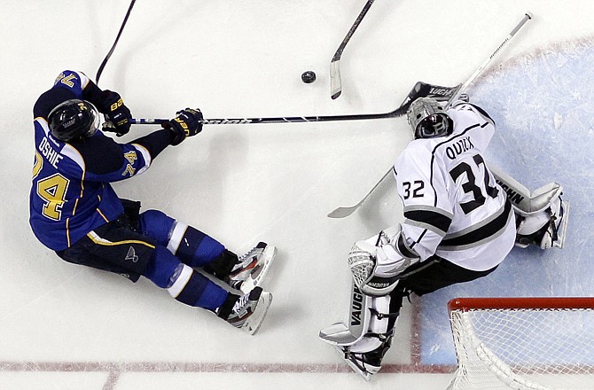 T.J. Oshie of the Blues tries to reach a loose puck as Kings goalie Jonathan Quick defends during the second period of Thursday night's game in St. Louis.