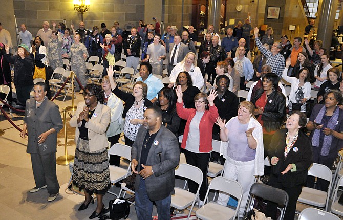 Participants of Thursday's National Day of Prayer rally sing in the rotunda as they wait for the day's speakers to arrive. The event was forced inside after rain started to fall during the outdoor prayer celebration.