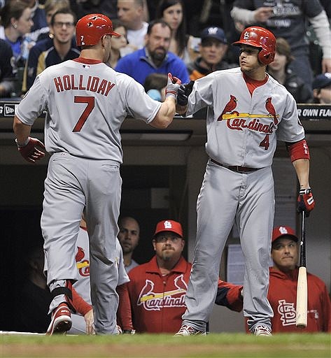 Matt Holliday of the Cardinals is congratulated by Yadier Molina after hitting a two-run home run in Friday night's game against the Brewers in Milwaukee.