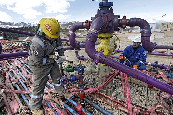Workers tend to a well head during a hydraulic fracturing operation at an Encana Oil & Gas (USA) Inc. gas well outside Rifle, in western Colorado. Technology created an energy revolution over the past decade, but Old Energy is winning.