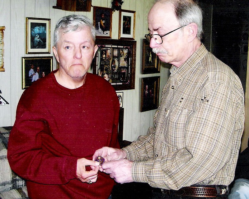 Bobbie Baker of Fulton, left, receives a Purple Heart medallion from Carl Skroback of West Allis, Wis., in memory of Baker's brother, Thomas "Mike" Baker, who was killed in action during the Vietnam War.