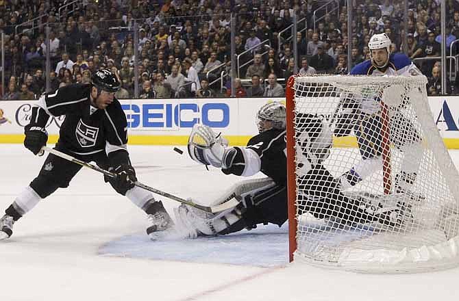 Los Angeles Kings goalie Jonathan Quick, center, stops a shot as Kings' Rob Scuderi, left, and St. Louis Blues' Chris Stewart watch during the third period in Game 3 of a first-round NHL hockey Stanley Cup playoff series in Los Angeles, Saturday, May 4, 2013. The Kings won 1-0.