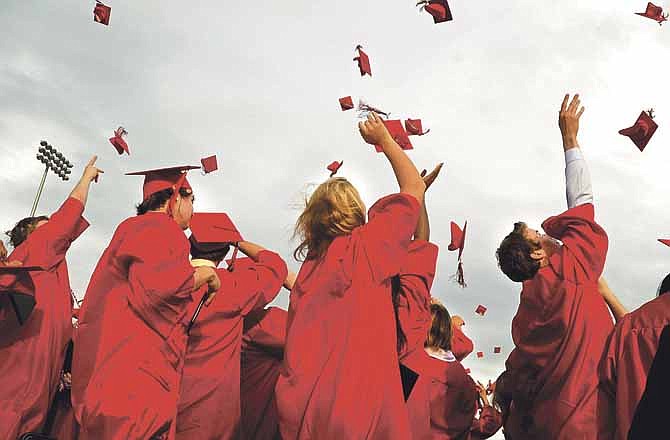 In this News Tribune 2012 file photo, members of the Jefferson City High School senior class toss their caps into the air following the conclusion of their graduation ceremony.