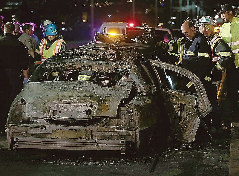 San Mateo County firefighters and California Highway Patrol personnel investigate the scene of a limousine fire on the westbound side of the San Mateo-Hayward Bridge in Foster City, Calif. Five women died when they were trapped in the limo that caught fire as they were traveling, and four others and the driver were able to escape. 