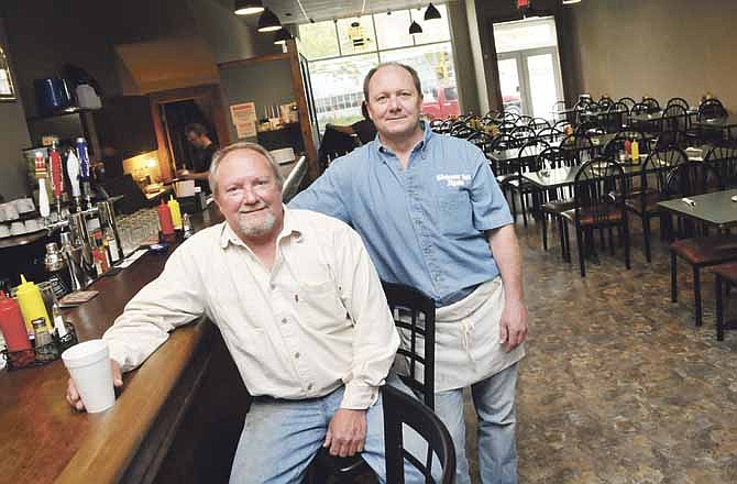 Steve Raithel, seated, has reopened Wel-com-Inn as Welcome Inn Again. His brother Eric stands ready to help fry the family's well-known chicken and prepare ham to serve to customers.