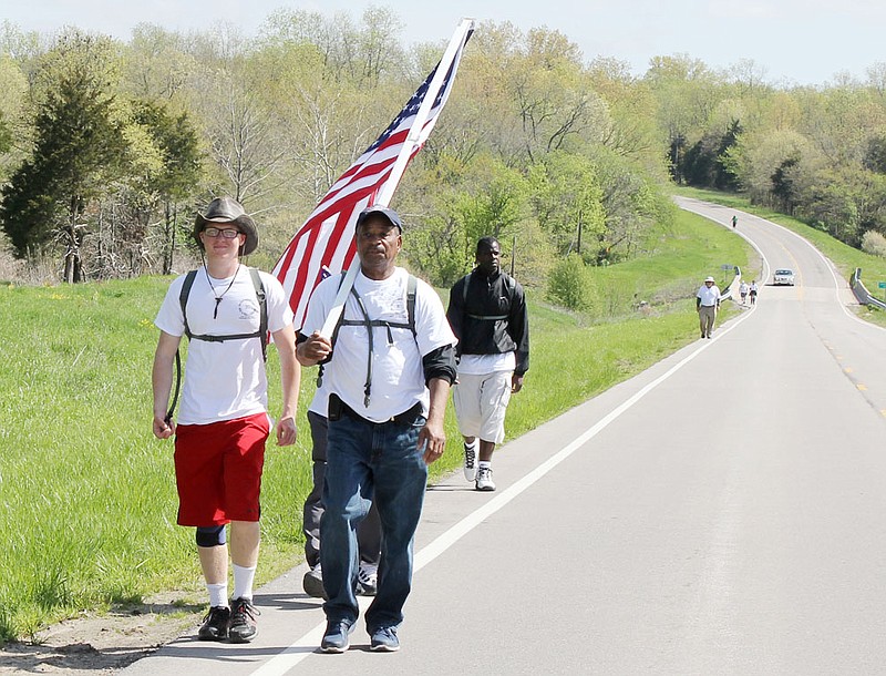 Chris Rice of St. Louis, left, grandson of Rev. Larry Rice of the New Life Evangelistic Center, leads a group of about 20 men walking along Route Z in Callaway County Monday morning as part of their week-long walk from St. Louis to Jefferson City to demonstrate for legislation improviing rights for the homelss.