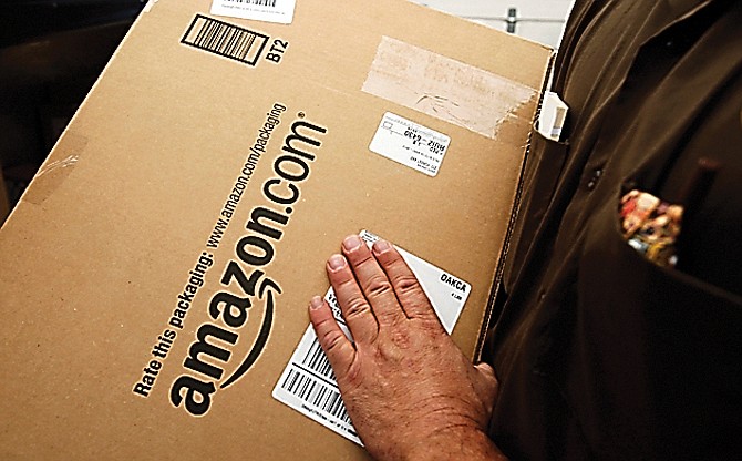 In this 2013 photo, an Amazon.com package is prepared for shipment by a United Parcel Service driver in Palo Alto, Calif.